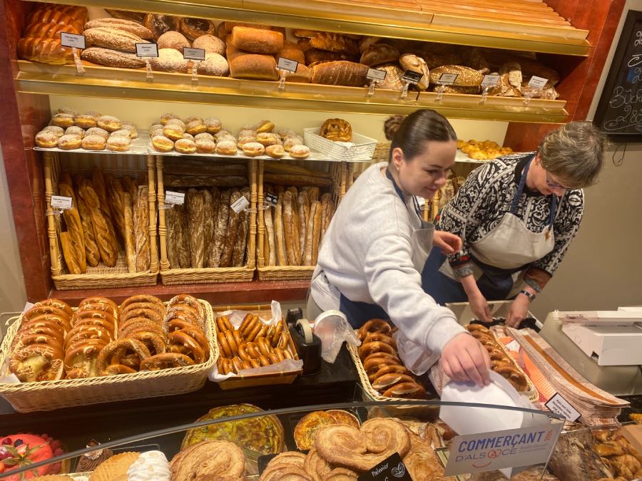 interior view of two staff in a patisserie with bread an pastries all around