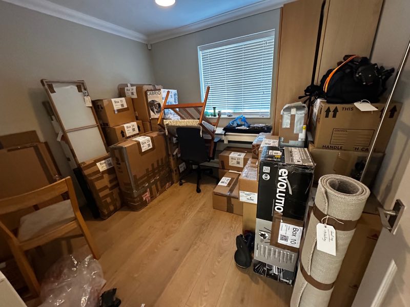 Room showing about half of a room full with boxes sporting labels with QR codes