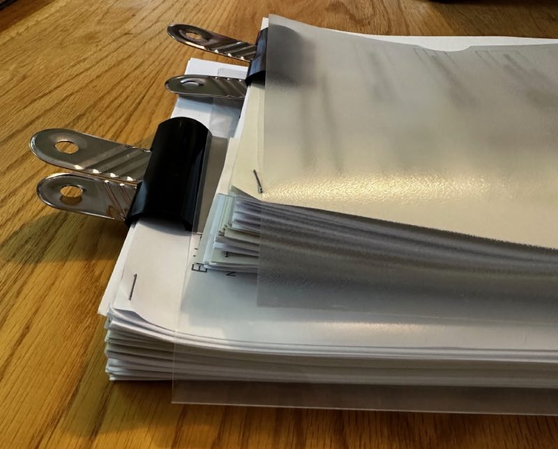 two neatly bundled piles of documents in folders